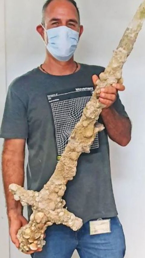 Ini penampakan pedang yang ditemukan, penuh lapisan kerang dan pasir.<br /><br />Foto: Badan Kepurbakalaan Israel (IAA)
