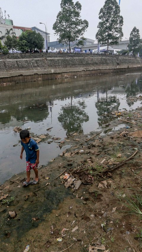 Seorang anak berjalan di tepian Sungai Ciliwung yang menyusut airnya karena kemarau.