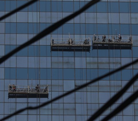 Pekerja membersihkan kaca gedung di Jalan Jenderal Sudirman, kawasan Semanggi, Jakarta, Sabtu (29/7/2023). Berdasarkan data Air Quality Indeks (AQI), polusi udara Jakarta kembali masuk kategori 