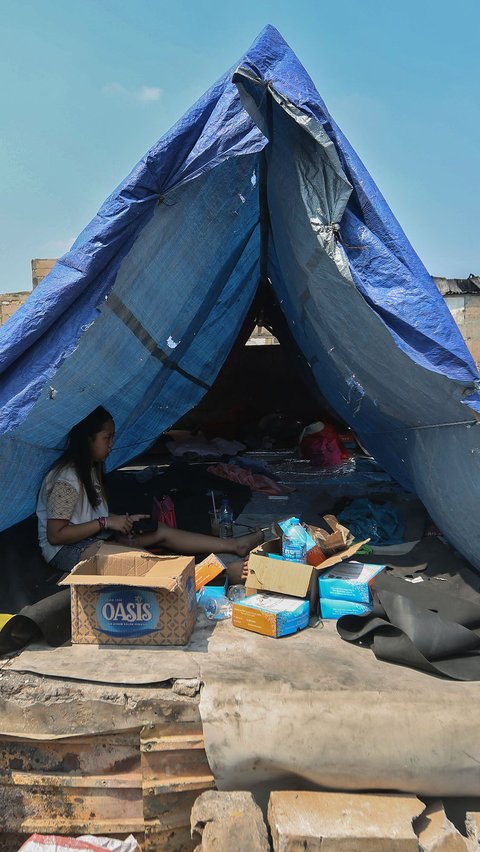 Sebagian warga terpaksa mendirikan tenda darurat dari terpal untuk dijadikan tempat tinggal sementara.