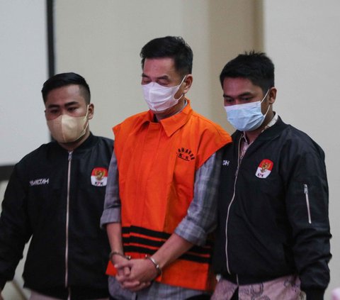 Dikawal oleh dua petugas penyidik KPK, Komisaris Utama PT Multi Grafika Cipta Sejati Mulsunadi Gunawan (MG) yang diborgol saat dihadirkan dalam konferensi pers di Gedung KPK, Jakarta, Senin (31/7/2023).