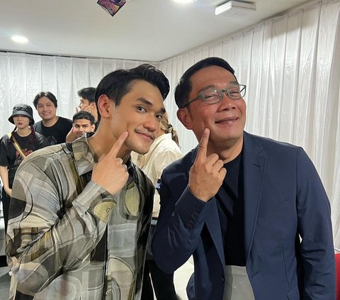 Atalia kerap menyebut suaminya memiliki kemiripan dengan Afgan. Tampak Ridwan Kamil berfoto bareng Afgan. Keduanya berpose menunjuk lesung pipi.