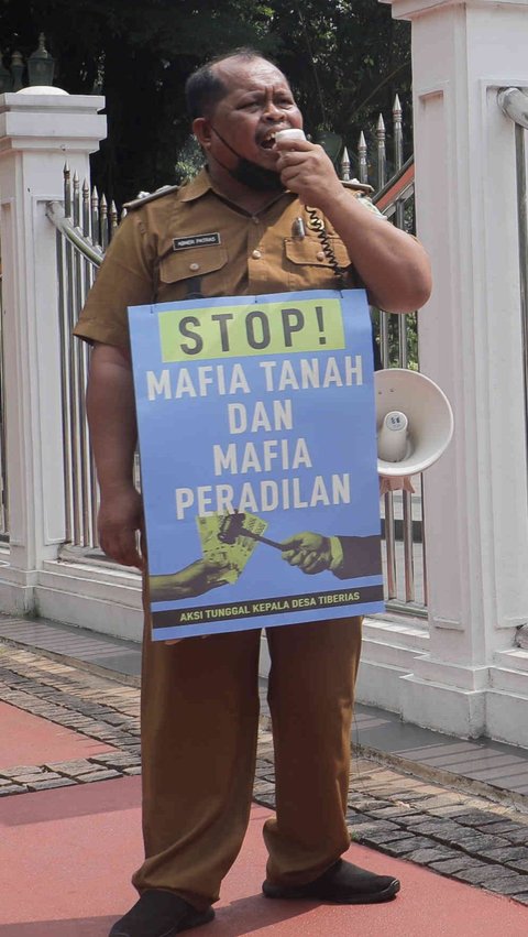 Dengan mengenakan pakaian dinas harian berwarna coklat, Abner melakukan demo tunggal di depan Gedung MA.