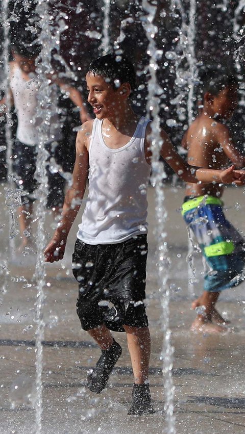 Tampak anak-anak meramaikan air mancur di taman kota. Ada pula yang bermain air di kanal dan berendam di belakang rumah.