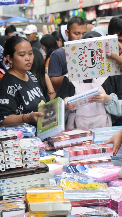 Potret kesibukan pengunjung yang memilih buku untuk anaknya.