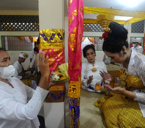 Gigi yang telah dipotong lantas diletakkan di atas sebuah kain berwarna cokelat kekuningan. Nantinya, didoakan bersama dengan sepiring sesaji.