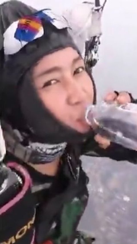 Prajurit wanita TNI minum air ketika melakukan terjun payung.