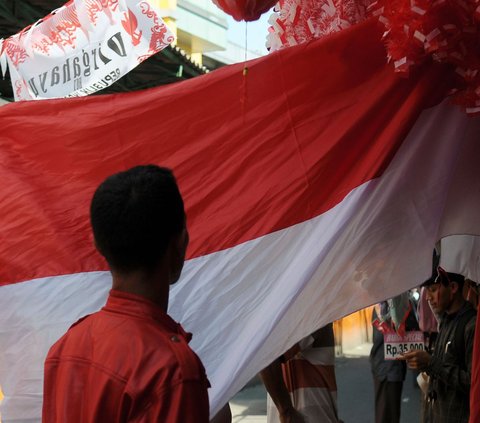 Warga melihat bentangan bendera merah putih yang dijual dengan aksesoris lainnya menjelang Hari Kemerdekaan Republik Indonesia ke-78 tahun di Pasar Jatinegara, Selasa (1/8/2023).