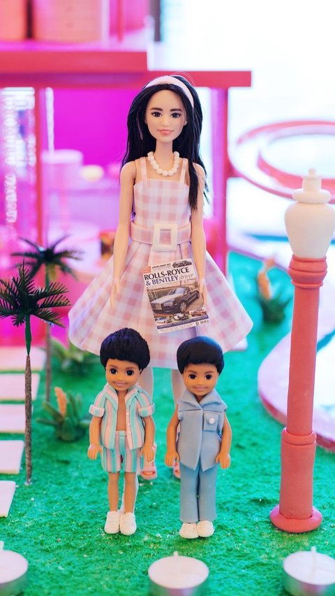 Kue  tersebut berbentuk pemandangan rumah ala Barbie lengkap dengan ornamennya.