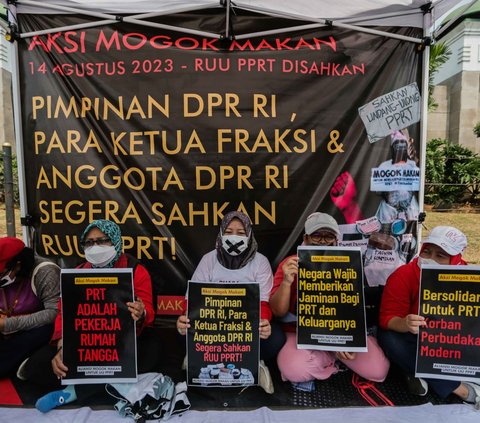 Sejumlah anggota aliansi Mogok Makan Untuk Undang Undang Perlindungan Pekerja Rumah Tangga (UU PPRT) membentangkan poster saat aksi di depan Gedung DPR, Jakarta, Senin (14/8/2023).