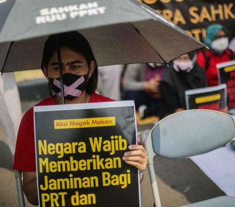 Tak hanya poster yang mereka bawa, payung hitam yang tulisan 'Sahkan RUU PPRT pun juga mereka bawa selama beraksi unju rasa.