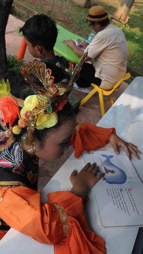 Antusiasme anak-anak dapat dilihat saat mereka asyik membaca buku cerita dongeng.