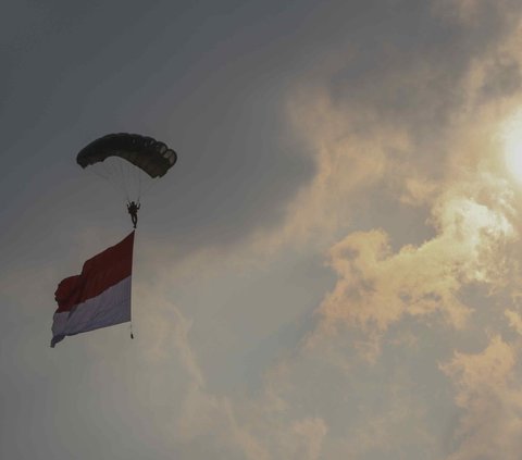 Pasukan TNI AD saat atrkasi terjun payung di Peringatan Hari Pramuka ke-62 tahun dan pembukaan Raimuna Nasional (Rainas) XII Tahun 2023 di Bumi Perkemahan dan Graha Wisata Pramuka (Buperta), Cibubur, Jakarta, Senin (14/8/2023).