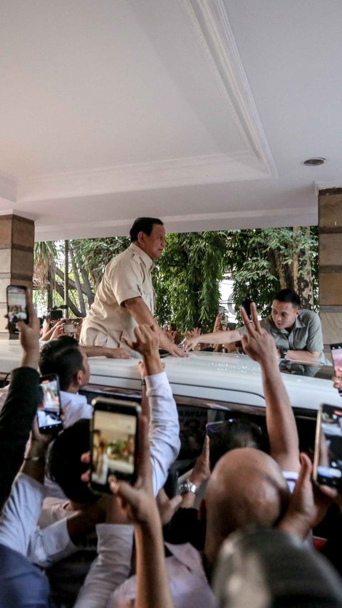 Ketua Umum Partai Gerindra Prabowo Subianto naik di atas mobilnya saat menyapa para relawan usai menghadiri acara peresmian rumah pemenangan relawan di Menteng, Jakarta, Selasa (15/8/2023).