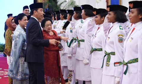 Presiden Jokowi secara simbolik memasangkan pin pengukuhan anggota Paskibraka kepada salah seorang anggota yang ditugaskan sebagai pemimpin upacara.