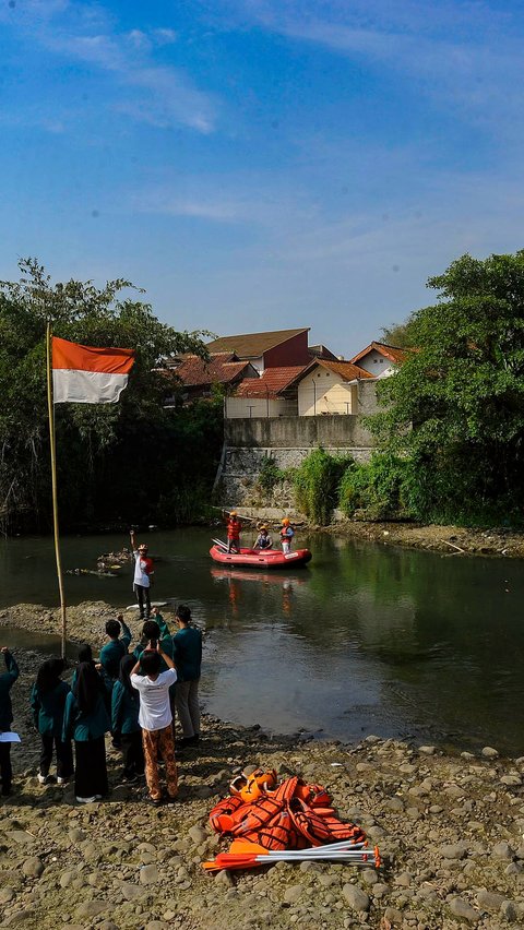 Warga di sana melaksanakan upacara bendera di tengah Sungai Ciliwung yang hampir kering akibat musim kemarau yang masih melanda sampai sekarang.