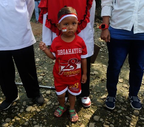 Tak hanya orang dewasa, sejumlah anak juga ikut meramaikan momen pengibaran bendera merah putih pada aliran Sungai Ciliwung yang hampir mengering di Kedung Halang Kota Bogor, Kamis (17/08/2023).