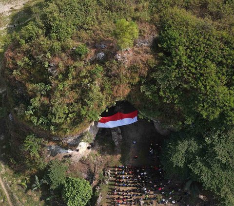 Foto udara memperlihatkan upacara pengibaran bendera merah putih pada HUT ke-78 Kemerdekaan RI di lokasi bekas tambang batu kapur Tebing Arpam, Gua Sigugula Karst Klapanunggal, Kabupaten Bogor, Jawa Barat, Kamis (17/8/2023).