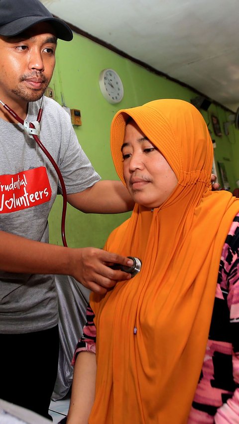 Seorang petugas kesehatan memeriksa seorang warga yang mengikuti konsultasi kesehatan bersama Prudential Indonesia dan Prudential Syariah.