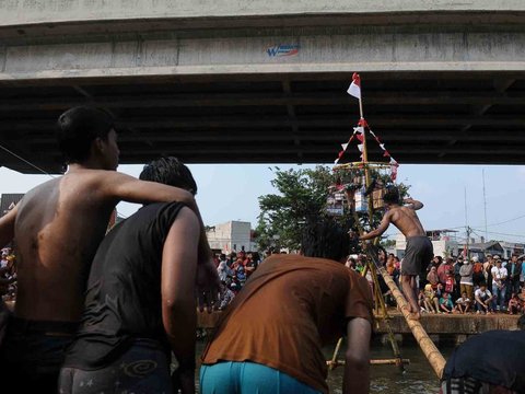 FOTO: Serunya Lomba Panjat Pinang Berhadiah Emas di Aliran Kalimalang, Gagal Jaga Keseimbangan Auto Nyebur