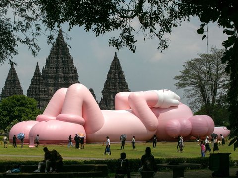 FOTO: Momen KAWS Liburan di Indonesia, Begini Potretnya Saat Asyik Rebahan di Candi Prambanan