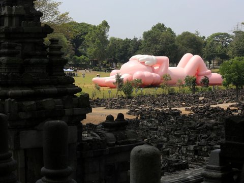 FOTO: Momen KAWS Liburan di Indonesia, Begini Potretnya Saat Asyik Rebahan di Candi Prambanan