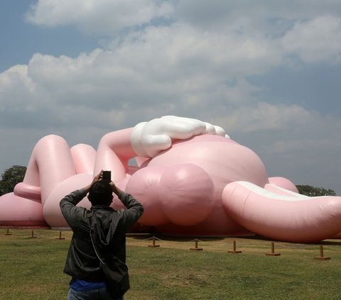 FOTO: Momen KAWS Liburan di Indonesia, Begini Potretnya Saat Asyik Rebahan di Candi Prambanan