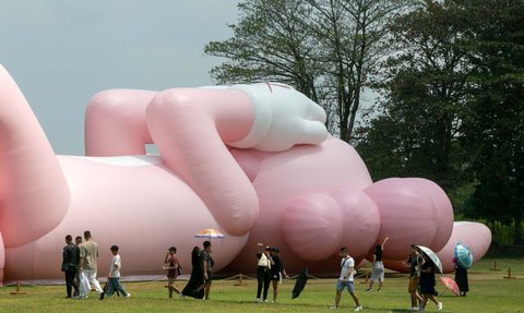 FOTO: Momen KAWS Liburan di Indonesia, Begini Potretnya Saat Asyik Rebahan di Candi Prambanan