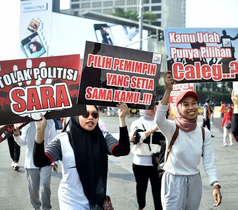 Sejumlah aktivis warga membawa beragam poster yang bertuliskan Sosialisasi Pemilu 2024 saat beraksi pada area Car Free Day (CFD) atau Hari Bebas Kendaraan Bermotor (HBKB) di Bundaran Hotel Indonesia, Jakarta, Minggu (20/8/2023).