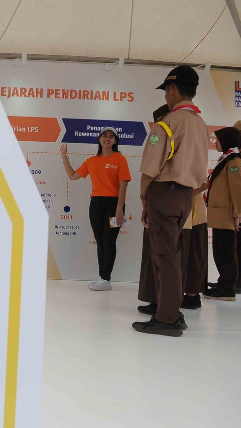 Peserta pramuka mendengarkan pengarah di depan bot Lembaga Penjamin Simpanan (LPS) pada acara Raimuna Nasional (Rainas) XII Tahun 2023 di Buperta, Jakarta Minggu (20/8/2023).