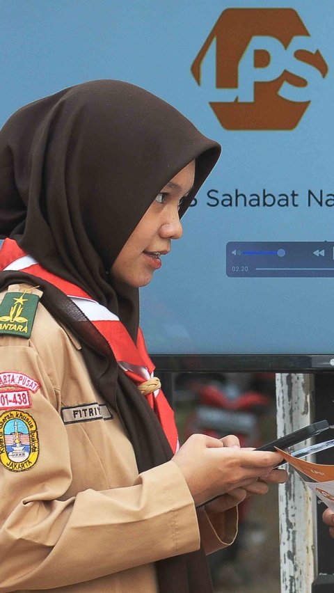 Pelajar anggota Pramuka peserta Raimuna Nasional (Rainas) XII Tahun 2023 sedang melihat brosur  lembaga Penjamin Simpanan (LPS) di Buperta, Jakarta Minggu (20/8/2023).