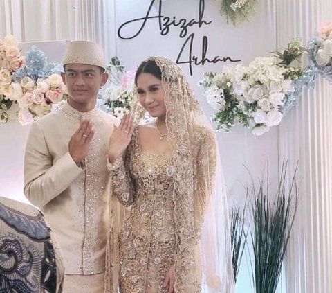 Pasangan ini tampak memamerkan cincin pernikahan setelah sah menjadi suami istri.