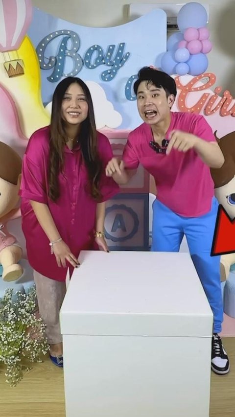 Dalam video tersebut terlihat dekorasi lucu berwarna pink dan biru, lengkap dengan kotak putih besar yang ada di depannya.
