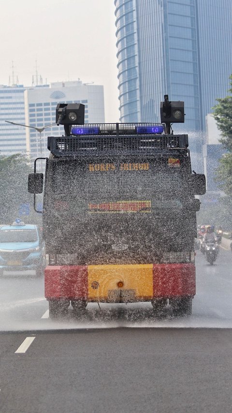 FOTO: Kurangi Polusi Udara dan Cuaca Panas, Tembakan Water Canon Basahi Kawasan Sudirman hingga Thamrin