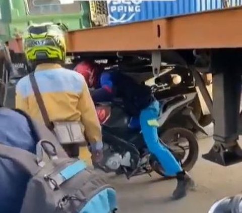 Demi Hindari Macet, Pengendara Motor Ini Nekat Lewati Kolong Truk Kontainer