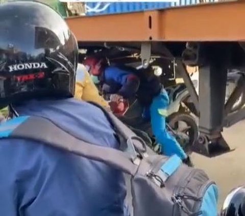 Demi Hindari Macet, Pengendara Motor Ini Nekat Lewati Kolong Truk Kontainer