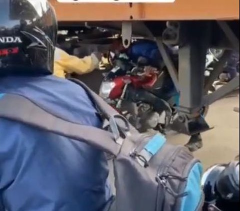 Demi Hindari Macet, Pengendara Motor Ini Nekat Lewati Kolong Truk Kontainer