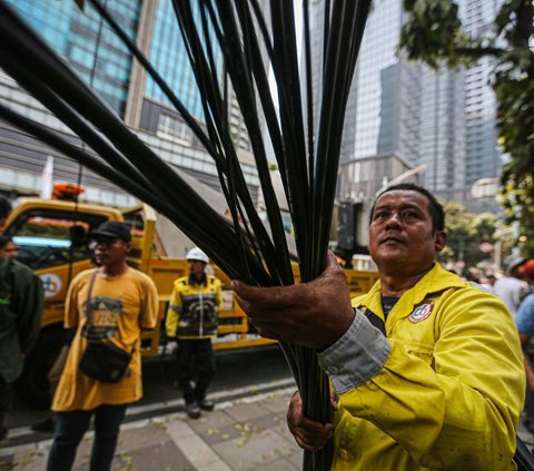 Petugas dari Dinas Bina Marga didampingi Jakarta Infrastruktur Propertindo (JIP) menarik kabel fiber optik yang semrawut saat melakukan penertiban di kawasan Jalan Senopati, Jakarta, Kamis (24/8/2023).