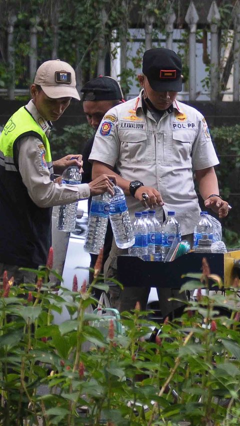 Satpol PP bersiap mengangkut sepeda dan barang dagangan pedagang kopi starling ke atas truk.