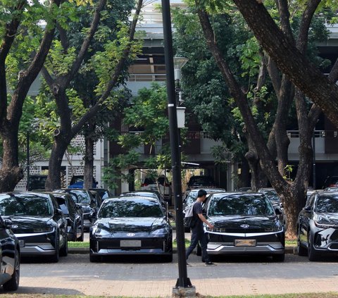 Di Parkir Timur Gelora Bung Karno (GBK) terlihat sejumlah petugas sibuk mengecek dan mempersiapkan mobil-mobil listrik dengan melakukan pemasangan pelat nomor.