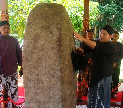 Bupati Trenggalek, Mochamad Nur Arifin membersihkan Prasasti Kamulan selama melakukan tradisi jamasan tujuh pusaka di Pendopo Kabupaten Trenggalek, Jawa Timur, Rabu (30/8/2023).