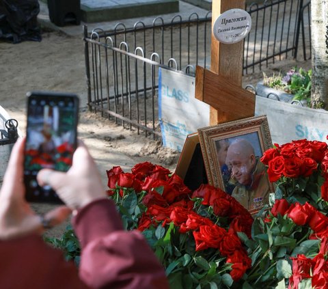 Setelah memberikan penghormatan terakhir, warga juga mengabadikan kuburan Yevgeny Prigozhin dengan kamera di ponselnya.