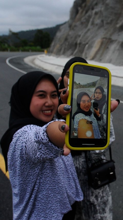 Ada yang berfoto selfie berdua dengan kamera ponselnya.