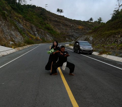Pasangan itu menunjukkan posenya dengan berdiri di tengah jalan Jalur Pantai Selatan yang menghubungkan Tulungagung-Trenggalek di Watulimo, Trenggalek Jawa Timur.