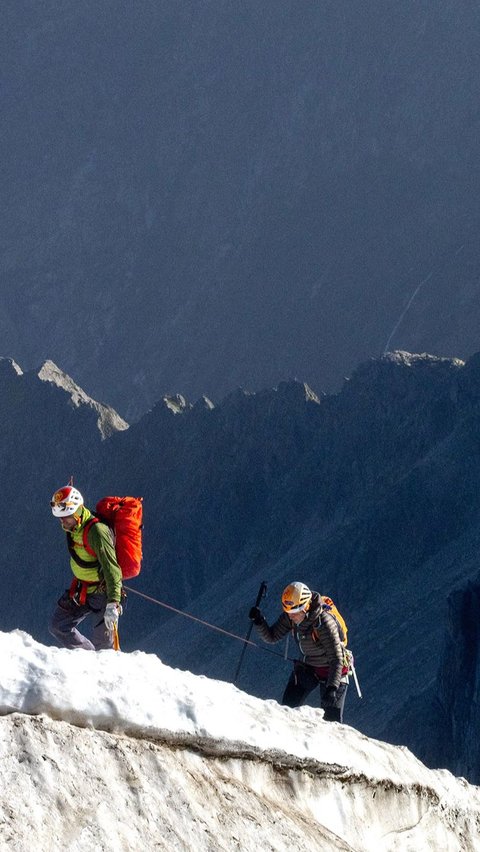 Sekelompok pendaki berjalan melewati salju yang menyelimuti Gunung Mont Blanc ketika terjadi fenomena gelombang panas.