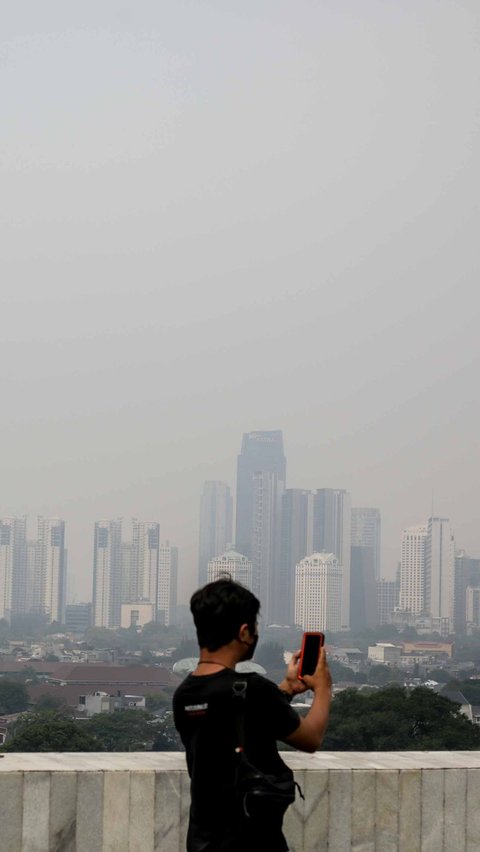 Seorang warga mengambil gambar kondisi polusi udara di Jakarta, pada Kamis (31/8) siang.