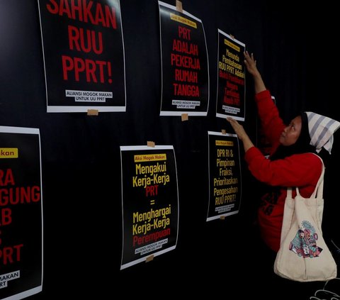 Aliansi Mogok Makan Untuk Undang Undang Perlindungan Pekerja Rumah Tangga (UU PPRT) menempelkan poster saat akan menggelar konferensi pers aksi mogok makan bergilir atau berpuasa massal di Gedung YLBHI, Jakarta, Minggu (6/7/23).