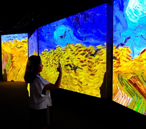 Pengunjung menggunakan kamera ponselnya mengabadikan display multimedia saat pameran Van Gogh Alive ditampilkan di Mal Taman Anggrek, Jakarta, Senin (07/08/2023).