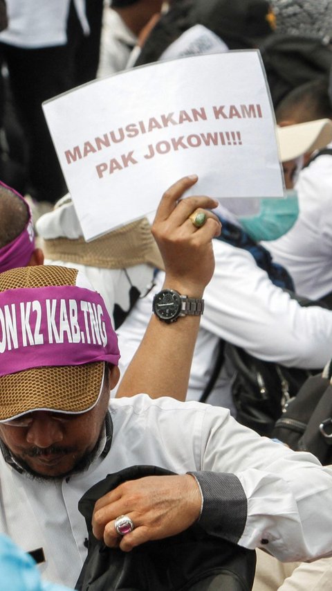 Dengan berpakaian seragam putih, mereka meminta Jokowi agar segera diangkat menjadi ASN.