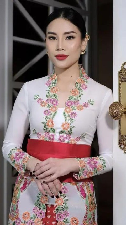 Dengan wajah oriental yang khas, Angela memukau dalam balutan kebaya model encim berwarna putih yang dipercantik dengan bordiran bunga beraneka warna.